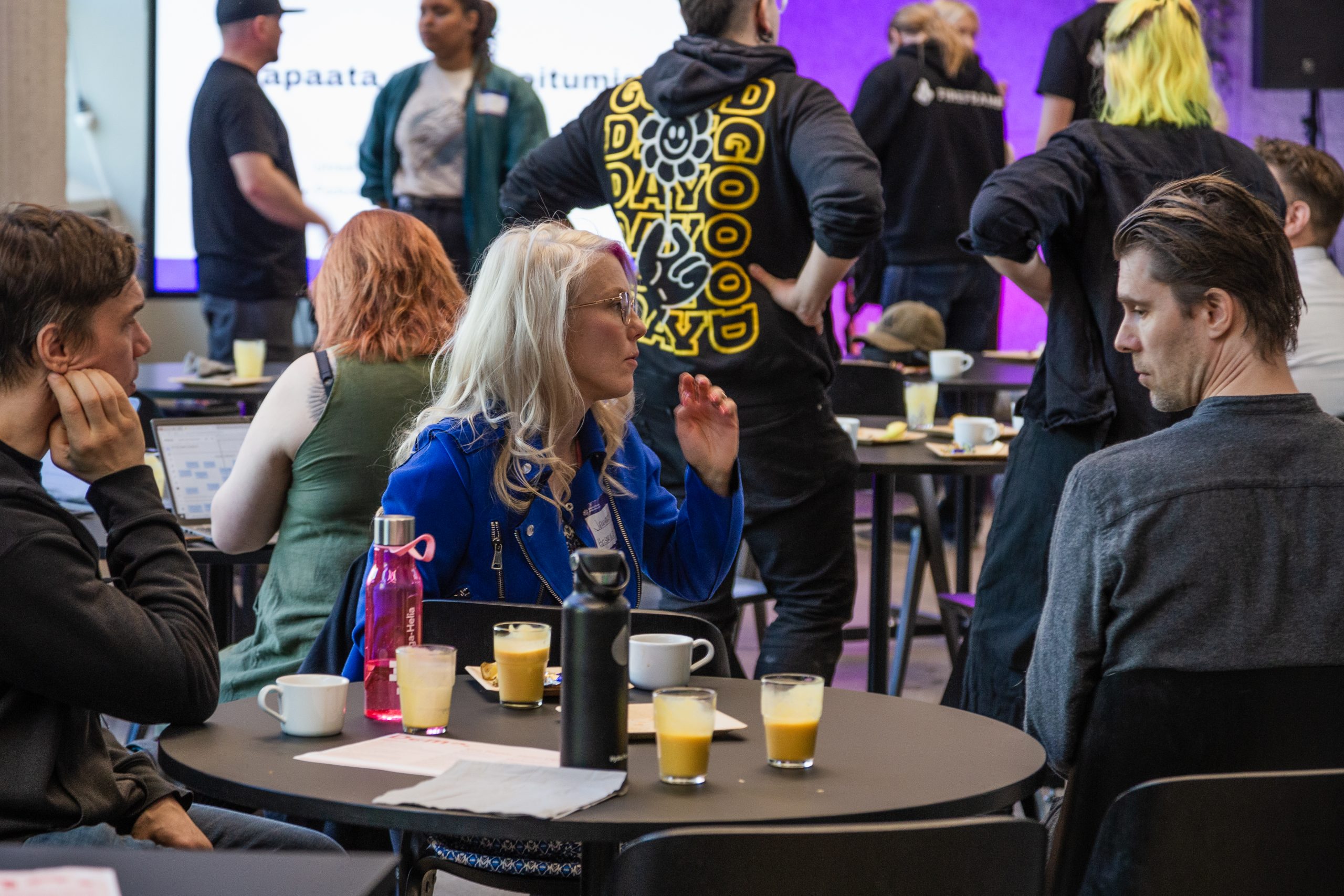 Kuva heTKInen-aamukahvituokiosta, missä ihmisiä on istumassa pöydän ääressä nauttimassa aamupalaa ja juttelemassa toistensa kanssa.